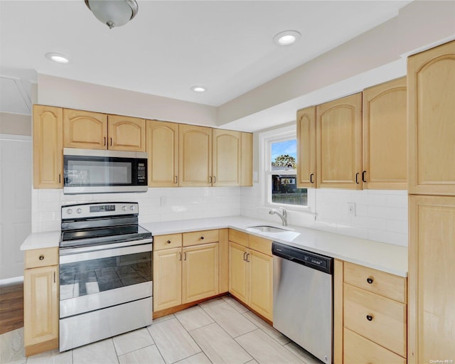 kitchen featuring light brown cabinets, sink, appliances with stainless steel finishes, tasteful backsplash, and light tile patterned flooring