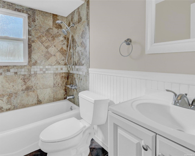 full bathroom featuring tiled shower / bath combo, toilet, and vanity