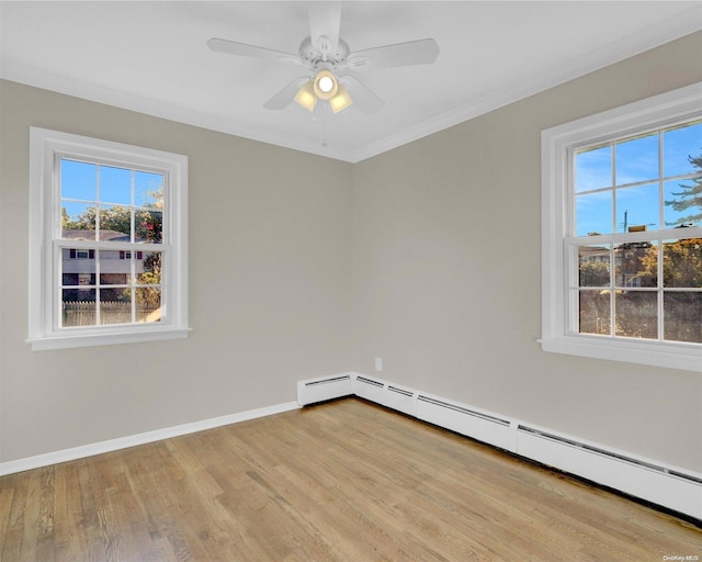 spare room featuring ornamental molding, light wood-type flooring, ceiling fan, and a baseboard heating unit