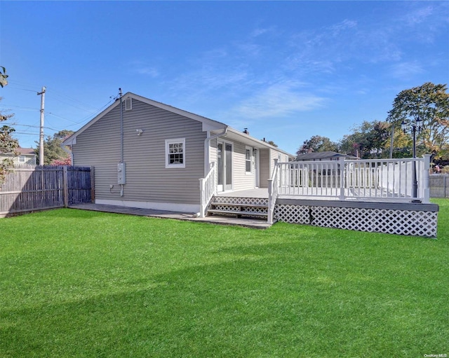 back of house featuring a wooden deck and a yard