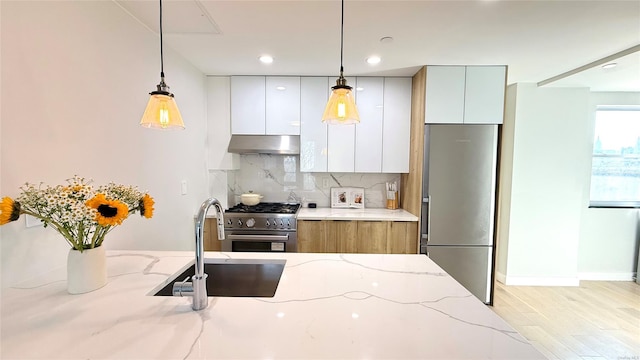 28-09 39th Ave Unit 5A, Long Island City, NY 11101 - kitchen featuring appliances with stainless steel finishes, under cabinet range hood, a sink, modern cabinets, and white cabinetry