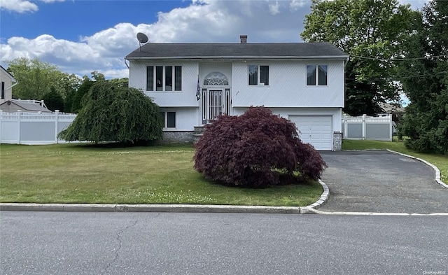 split foyer home featuring a front lawn and a garage