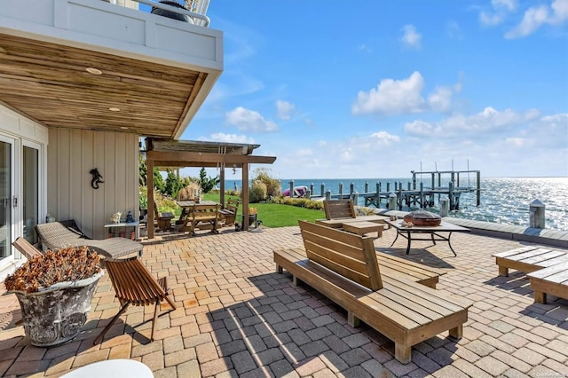 view of patio with a fire pit and a water view