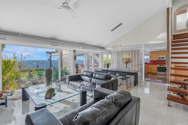 living room featuring ceiling fan, a water view, and lofted ceiling