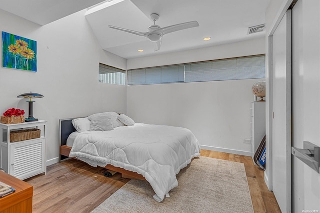 bedroom with ceiling fan, light hardwood / wood-style floors, and a closet