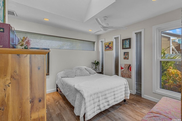 bedroom featuring ceiling fan, wood-type flooring, and vaulted ceiling