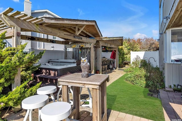 view of patio / terrace featuring a bar and a hot tub