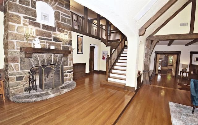 interior space featuring hardwood / wood-style flooring, high vaulted ceiling, a fireplace, and beamed ceiling