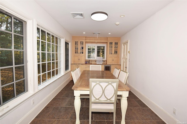 dining area featuring dark tile patterned floors and beverage cooler