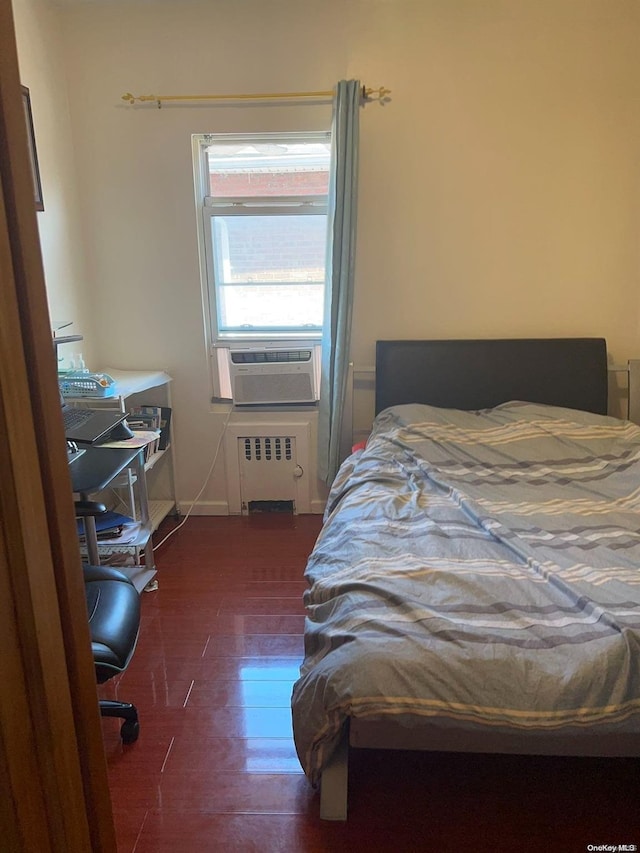 bedroom featuring radiator heating unit, dark hardwood / wood-style flooring, and cooling unit