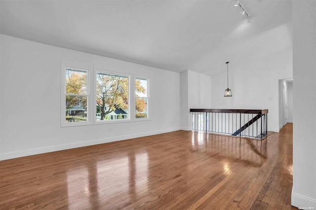 unfurnished living room with hardwood / wood-style floors and rail lighting