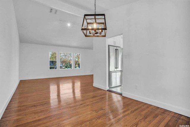 unfurnished living room featuring a notable chandelier, wood-type flooring, and a high ceiling