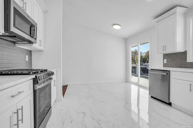 kitchen with white cabinetry, backsplash, and appliances with stainless steel finishes