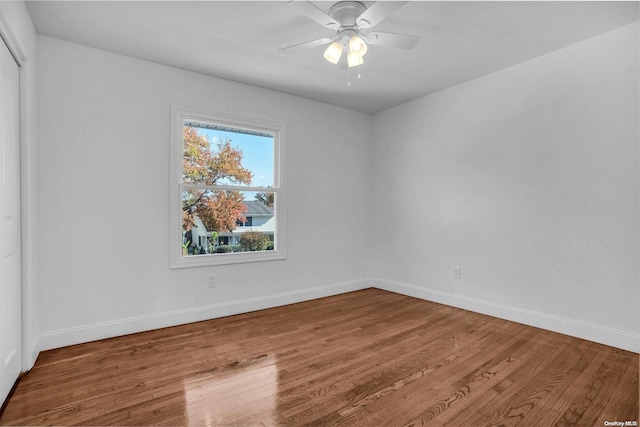 empty room with hardwood / wood-style floors and ceiling fan