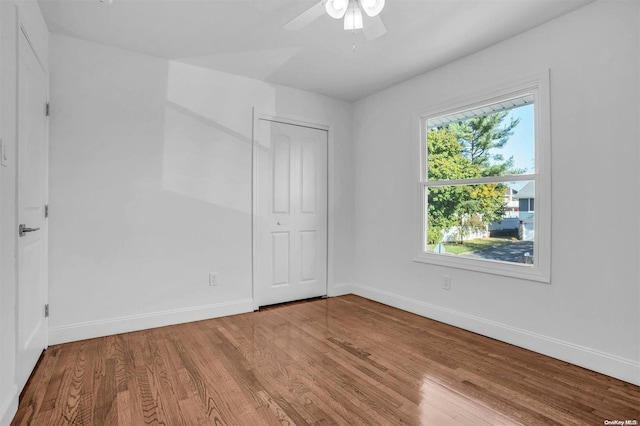 unfurnished bedroom with hardwood / wood-style floors, ceiling fan, and a closet