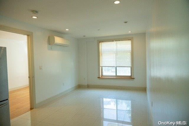 spare room with light wood-type flooring and a wall mounted AC