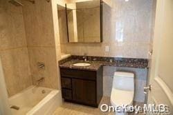 full bathroom with vanity,  shower combination, and toilet