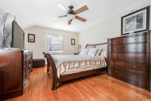 bedroom with ceiling fan, light hardwood / wood-style floors, and lofted ceiling