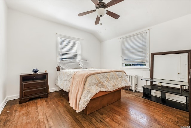 bedroom with ceiling fan, dark hardwood / wood-style flooring, radiator, and vaulted ceiling