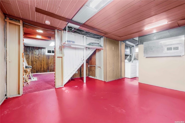 basement featuring wood walls and independent washer and dryer