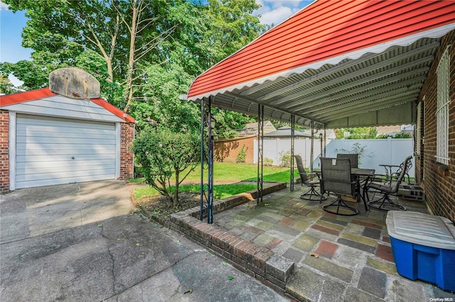 view of patio / terrace with a carport, a garage, and an outbuilding