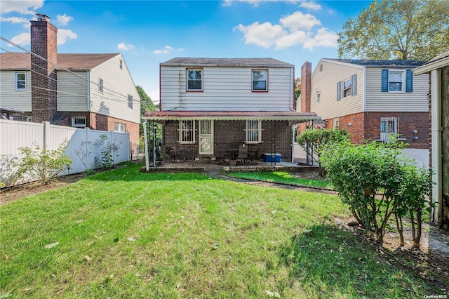 rear view of house with a yard and a patio area