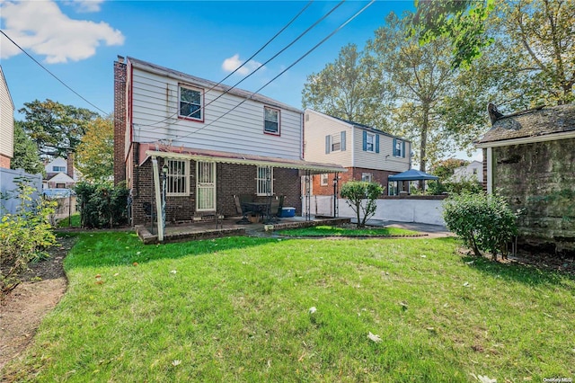 back of property with a patio area and a yard