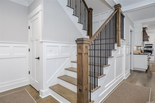 staircase with crown molding and hardwood / wood-style floors