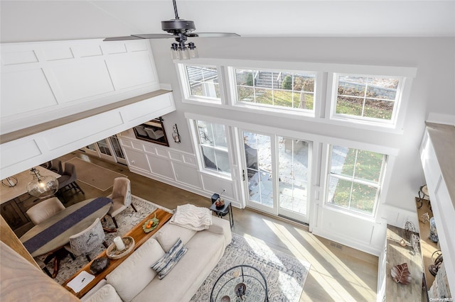 living room featuring ceiling fan and high vaulted ceiling