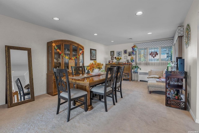 carpeted dining area with radiator