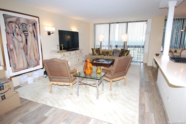 living room featuring ornate columns and light wood-type flooring