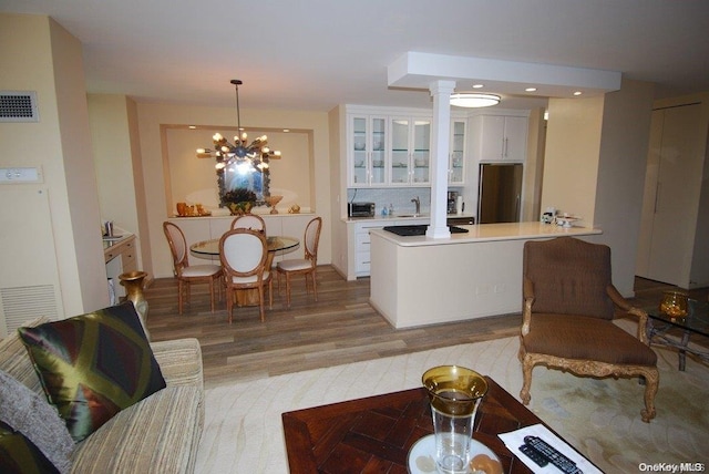 living room with hardwood / wood-style floors, a chandelier, and sink