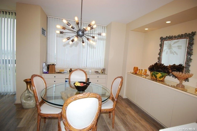 dining space with dark hardwood / wood-style floors and an inviting chandelier