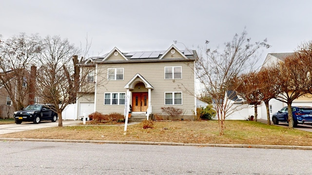 view of property with a front yard and solar panels