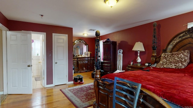 bedroom featuring ensuite bathroom and hardwood / wood-style floors