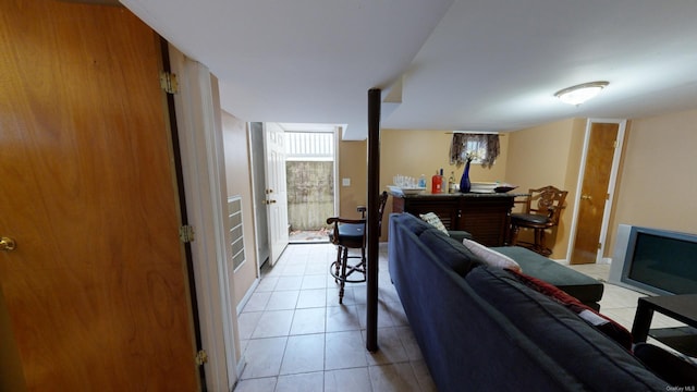 living room with light tile patterned floors and indoor bar