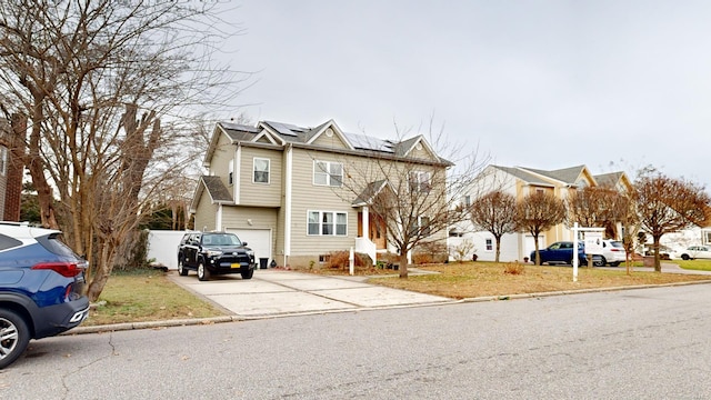 view of property featuring a garage, a front yard, and solar panels