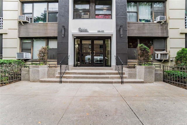98-22 63rd Dr Unit 5-E, Rego Park, NY 11374 - view of exterior entry with french doors, cooling unit, and stucco siding