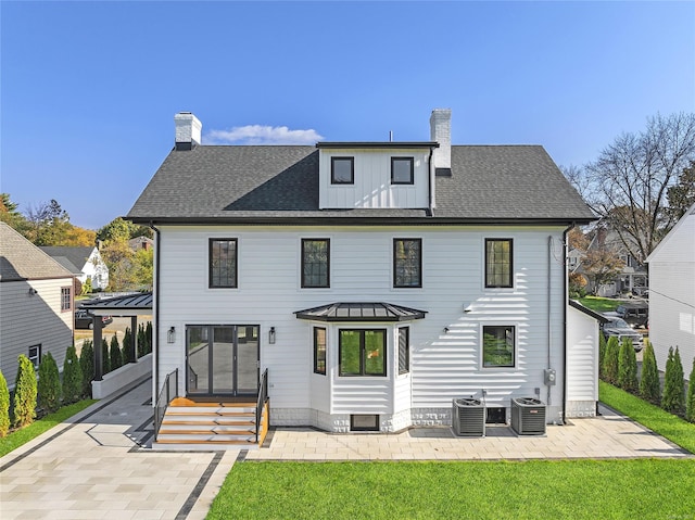 rear view of property with a lawn, central AC unit, and a patio area