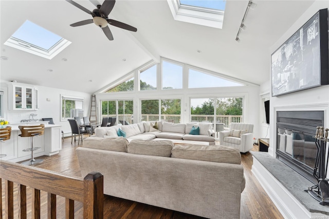 living room featuring high vaulted ceiling, ceiling fan, dark wood-type flooring, and a wealth of natural light