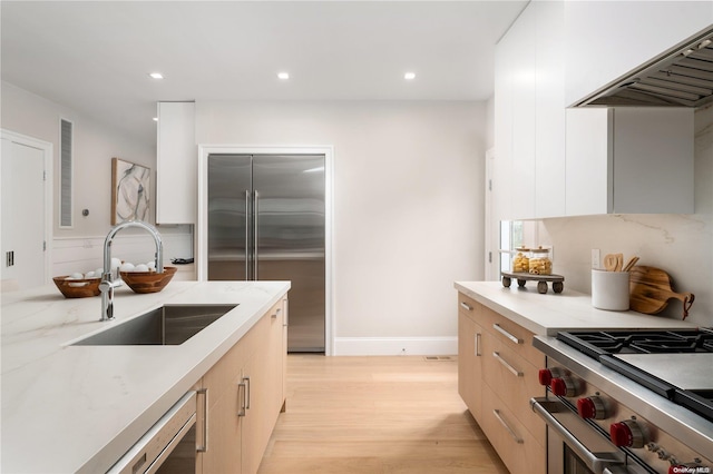 kitchen featuring light hardwood / wood-style floors, high quality appliances, sink, and light brown cabinetry