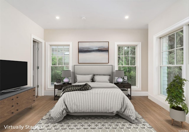 bedroom featuring light hardwood / wood-style floors and multiple windows