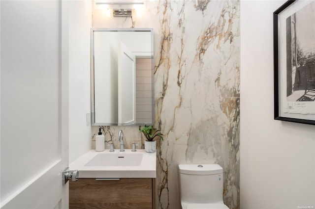 bathroom with vanity, toilet, and backsplash