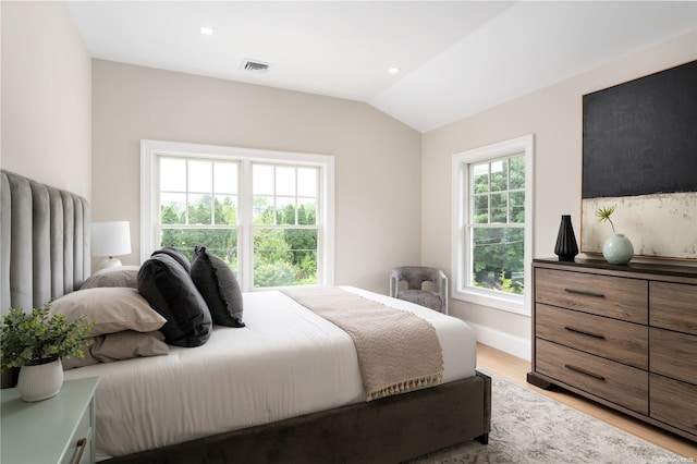 bedroom with light wood-type flooring and vaulted ceiling