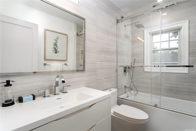 full bathroom with decorative backsplash, vanity, shower / bath combination with glass door, tile walls, and toilet