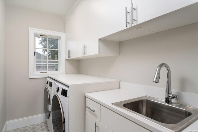 washroom with cabinets, washing machine and dryer, and sink