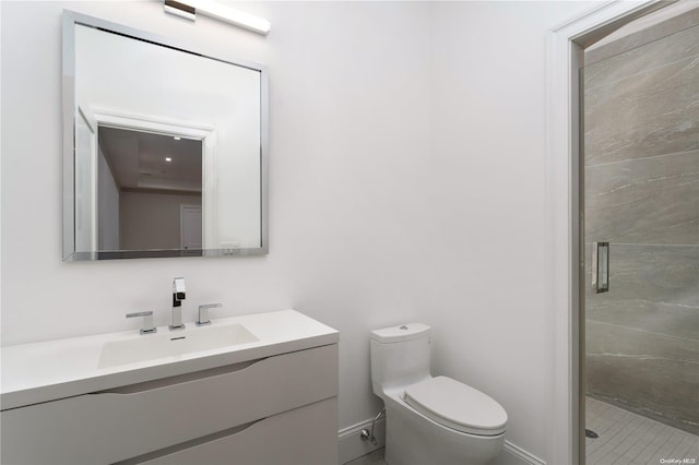 bathroom featuring tile patterned floors, vanity, toilet, and a shower with shower door