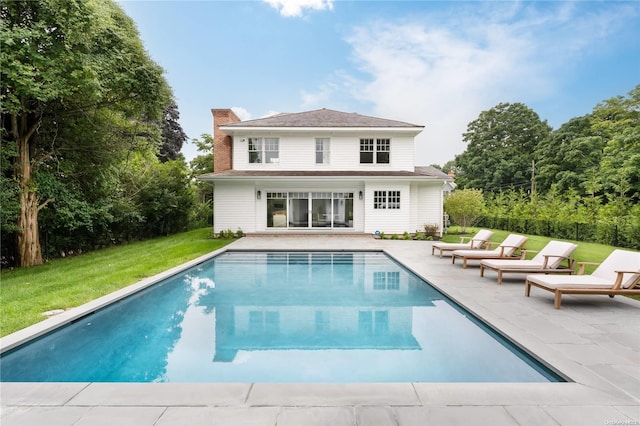 rear view of property featuring a lawn and a patio area