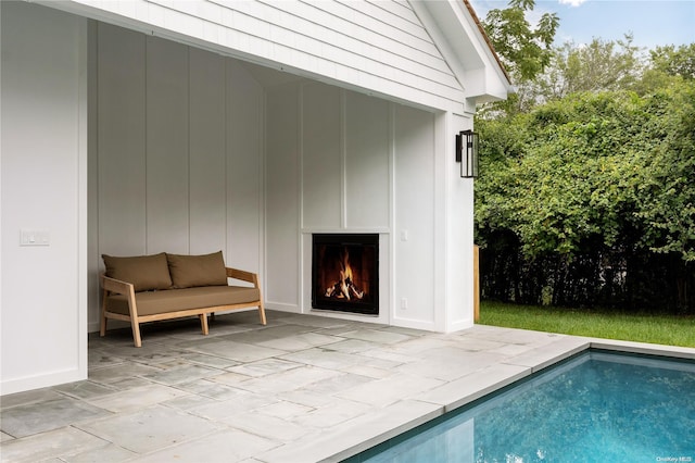 view of swimming pool with a fireplace and a patio