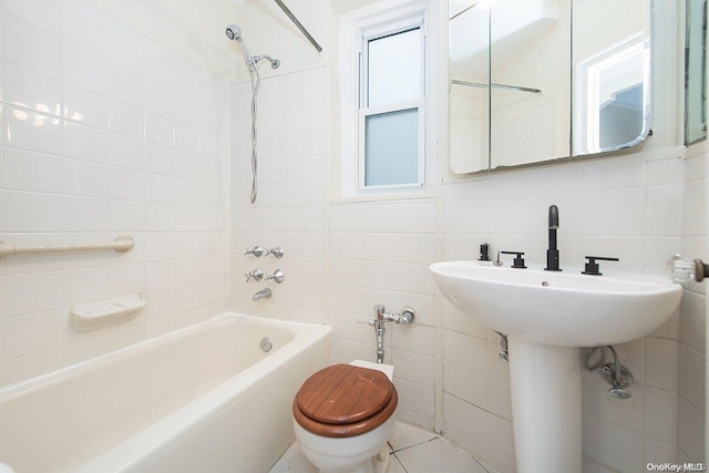 bathroom featuring toilet, tiled shower / bath, tile walls, and tasteful backsplash